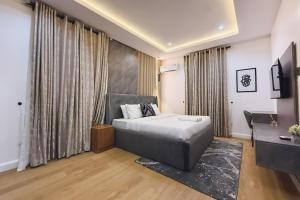 a bedroom with a bed and a desk and a television at Macdestly Apartments in Abuja