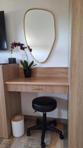 a desk with a mirror and a black chair at Petite Maison indépendante. in Béziers