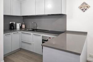a kitchen with white cabinets and a sink at Maison Michela Sorrento in Sorrento +8 photos