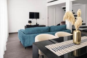 a living room with a blue couch and a table at Maison Michela Sorrento in Sorrento