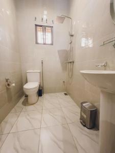 a white bathroom with a toilet and a sink at Macdestly Apartments in Abuja +42 photos