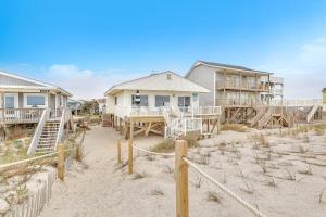 a house on the beach with a table and chairs at Lisa Lu in Oak Island