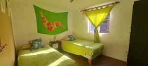 a small room with two beds and a window at Hare Te Maori in Hanga Roa