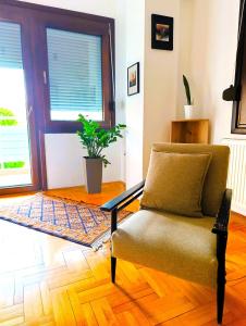 a living room with a chair in front of a door at Hera Sweet Apartment in Niš