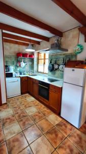 a kitchen with a white refrigerator and a stove at La casa del Torreón in San Isidro