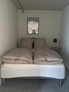 a bed with two pillows on it in a bedroom at Gæstehuset Rosenvang in Bogense