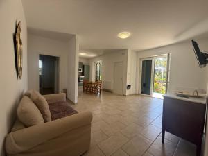 a living room with a couch and a dining room at Villino Frizza in Capo Vaticano