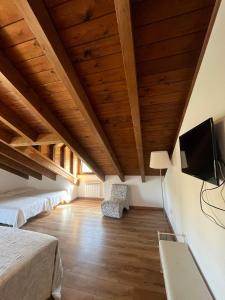 a bedroom with two beds and a flat screen tv at HOTEL RURAL Casa Campo in Abay