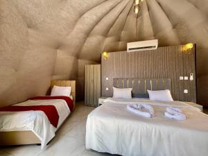 a bedroom with two beds with towels on them at Wadi rum trips in Wadi Rum