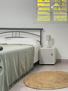 a bedroom with a bed and a night stand with a lamp at Villa Serenity in Les Abymes
