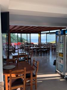 a restaurant with wooden tables and chairs and windows at Restorant Hotel Niku in Draç +22 photos