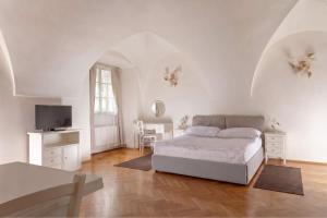 a white bedroom with a bed and a tv at Three Golden Crowns Apartments in Prague