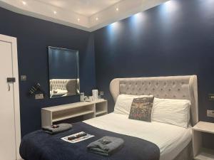 a bedroom with a bed with a mirror on the wall at The Jubilee Hotel East - with NEWLY REFURBISHED SPA FACILITIES - GAMESPIT - AND SMOKEHOUSE in Weymouth