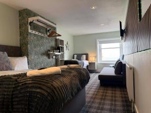 a hotel room with a bed and a couch at The Jubilee Hotel East - with NEWLY REFURBISHED SPA FACILITIES - GAMESPIT - AND SMOKEHOUSE in Weymouth