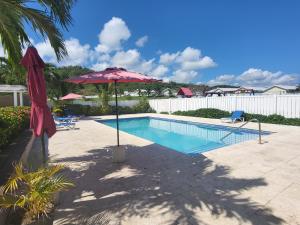 a swimming pool with a pink umbrella and a swimming pool at Beit Elohim in Lucea