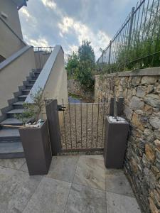 a gate with a stone wall and a staircase at Domus cinque in Borghetto Santo Spirito