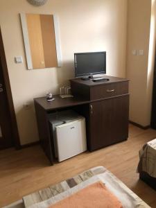 a room with a desk with a flat screen tv at Семеен хотел Струма in Boboshevo