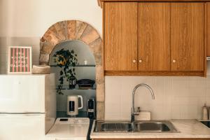 a kitchen with a sink and a white refrigerator at Tonella Studio in Corfu