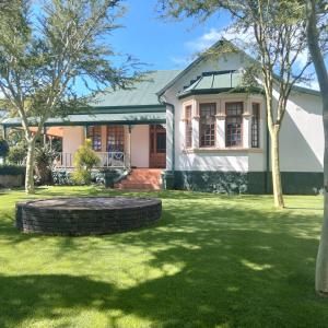 a house with a green lawn in front of it at Lekkerrus guesthouse in Krugersdorp +5 photos