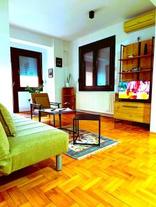 a living room with a couch and a television at Hera Sweet Apartment in Niš