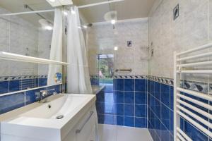 a bathroom with a white sink and blue tiles at L'Océane in Apremont