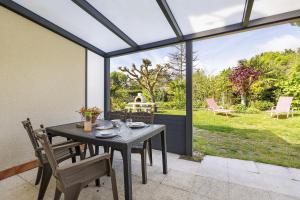 a dining room with a table and chairs on a patio at L'Océane in Apremont