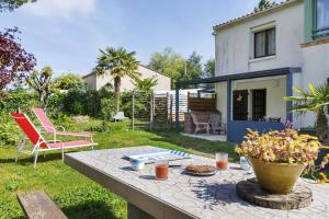 a patio with a table in the yard of a house at L'Océane in Apremont