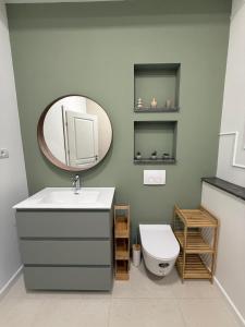 a bathroom with a sink and a mirror and a toilet at Tomis Villa Center Studio in Constanţa +18 photos