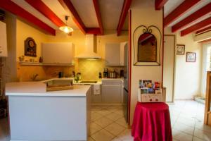 a kitchen with red and white ceilings and a table at Domaine de pommarede in Carsac-Aillac