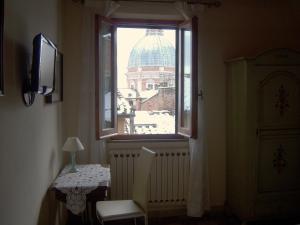 ein Fenster in einem Zimmer mit Blick auf ein Gebäude in der Unterkunft B&B Dei Rossi in Siena