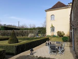 a table and chairs in a garden with a building at Domaine de pommarede in Carsac-Aillac