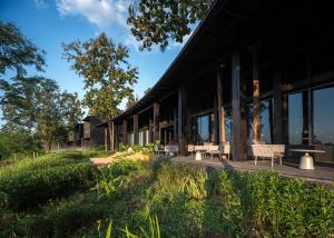 a building with windows and a bench in the grass at Sataa Resort Nan in Nan