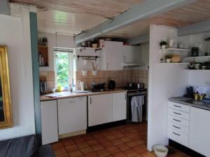a small kitchen with white cabinets and a window at Small House ærø in Marstal