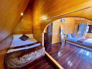 a room with two beds in a wooden room at tiny house in Ấp An Kroët