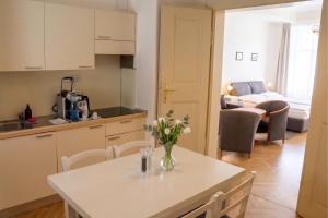 a kitchen and living room with a table with flowers on it at Three Golden Crowns Apartments in Prague +45 photos