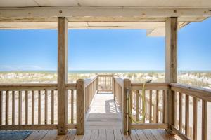 a wooden porch with a view of the beach at Lowe Tide in Oak Island