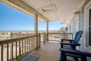 a porch with a blue chair and a view of the beach at Lowe Tide in Oak Island