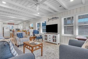 a living room with couches and a flat screen tv at Lowe Tide in Oak Island +52 photos