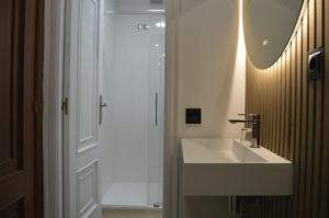 a white bathroom with a sink and a mirror at Hotel Marín in Marín