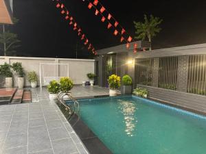 a swimming pool in a backyard at night at Villa Ban Mai in Tài Xá