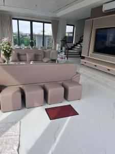 a living room with a large couch and a tv at Villa Ban Mai in Tài Xá