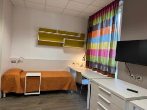a room with a bed and a desk and a television at Campus Circuito 71 - Casa per Ferie in Pescara