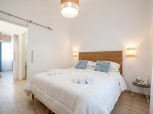a bedroom with a large white bed with towels on it at Casa Bambu in Polignano a Mare