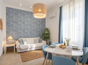 a living room with a white couch and blue chairs at Casa Bambu in Polignano a Mare