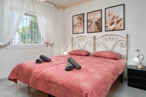 a bedroom with a red bed with black slippers on it at Apartamento Bellavista Torrox Park in Torrox