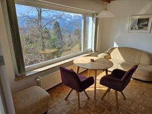 a living room with a table and chairs and a window at Haus am Hügel in Millstatt