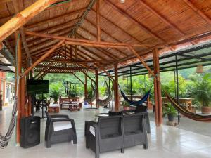 a large pavilion with hammocks and tables and chairs at Cabañas Spacetatacoa in Villavieja