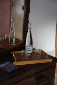 two bottles and glasses sitting on a wooden table at Riad Beldi by MaHa in Oulad Teïma +72 photos