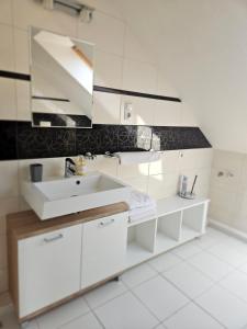 a white bathroom with a sink and a mirror at Orchidea Apartmanház Egerszalók in Egerszalók +17 photos