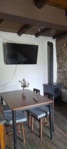 a wooden table with chairs and a stove in a room at Casa do Freire - Serra da Estrela in Aguincho